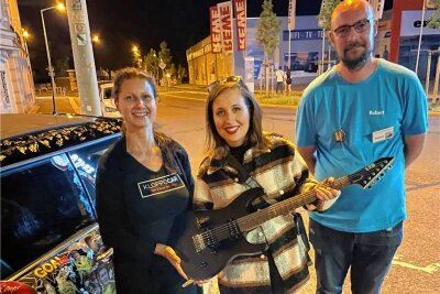 Kloppocar-Aktion in Freiberg: Wie viel Geld konnte gesammelt werden? - Alice Merton (M. mit Robert Ahnert und Mandy Hofmann) spendete eine von ihr signierte Gitarre an das Kloppocar.