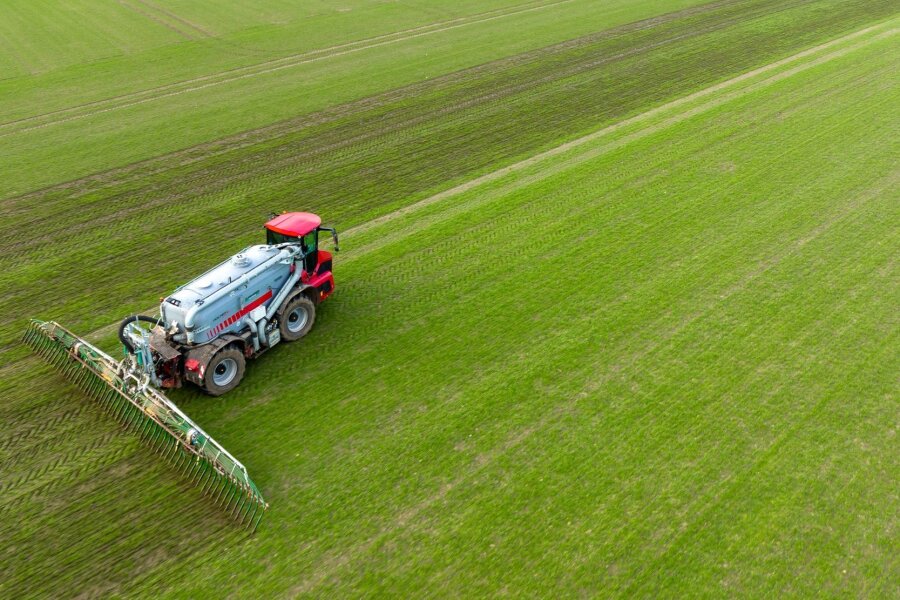 Koalition einig bei neuem Düngegesetz - Ein Landwirt bringt mit seinem Gespann Gülle im sogenannten Schleppschuh Verfahren auf einem Feld aus.