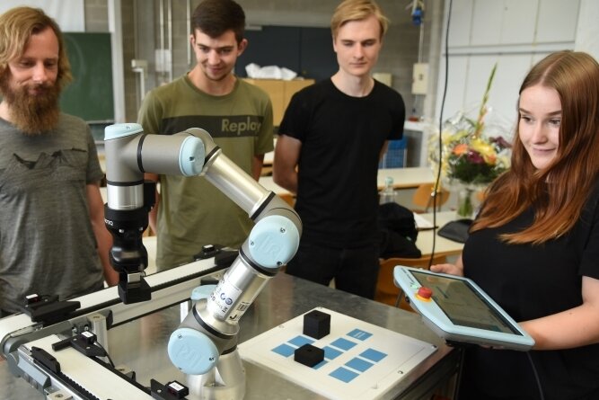 Kollege Roboter wirbt für Industriejobs - Die Roboter-Technik soll das Interesse bei angehenden Lehrlingen für Berufe in der Industriebranche wecken. Berufsschullehrer Christian Scheer (links) hat zusammen mit den Azubis Max Fuchs Anthony Thierbach und Esmeralda Pätz (von links) den Roboter am Berufsschulzentrum in Oelsnitz vorgeführt. 