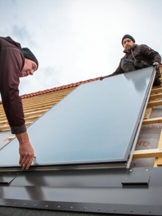 Kollektoren kommen per Kran - Für die Solarthermieanlage wurden 16 Sonnenkollektoren auf dem Dach montiert.