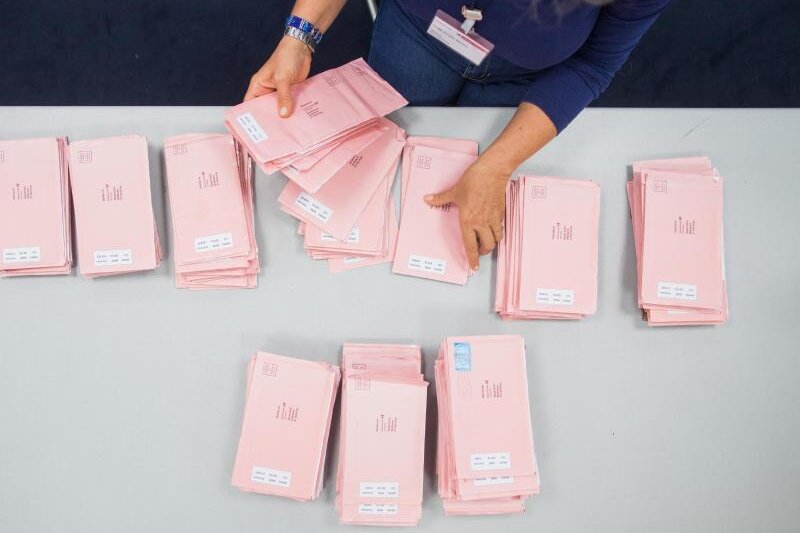            Eine Wahlhelferin sortiert Wahlbriefe.
