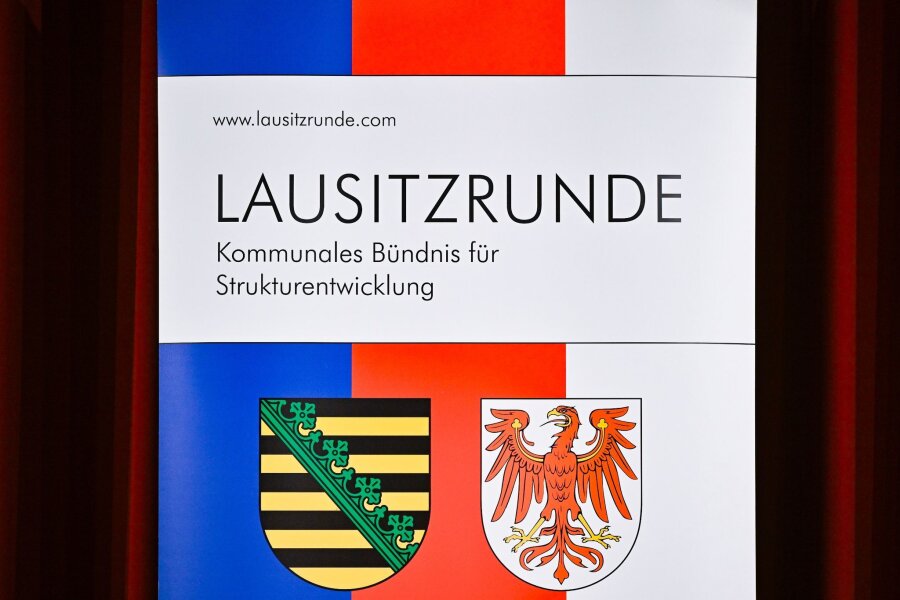 Kommunen einig: Wollen erstes "Net Zero Valley" werden - Ein Transparent mit den Wappen von Sachsen (l) und Brandenburg der Großen Lausitzrunde.