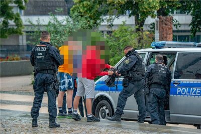 Kontrollen in der Chemnitzer Innenstadt: So wollen Ordnungsamt und Polizei für Ruhe sorgen - Polizeibeamte kontrollieren eine Gruppe von Jugendlichen im Stadthallenpark. Mit derlei verdachtsunabhängigen Durchsuchungen soll Drogen- und Gewaltkriminalität bekämpft werden. 