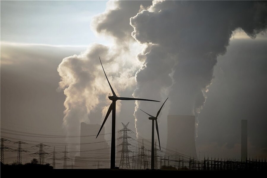 Kosten der Klimawende weiterhin unklar - Windräder vor einem Braunkohlekraftwerk.Wirtschaftsforscher warnen vor der Illusion, dass es bei der Klimawende nur Gewinner geben werde.
