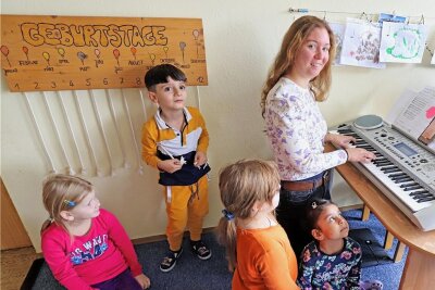 Kreativ-Protest in Freiberg gegen Streichpläne: Warum Sprach-Kitas so wichtig sind - Musikpädagogin Louisa Reh (M.) übt gemeinsam mit Erzieherin Madlen Lohmann und den Kindern Lieder ein. Dazu wird auch getanzt.