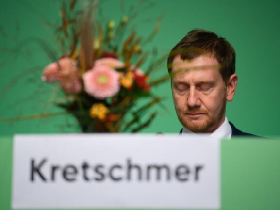            Michael Kretschmer (CDU) sitzt auf dem Landesparteitag der CDU Sachsen nach seiner Wiederwahl hinter seinem Blumenstrauß.