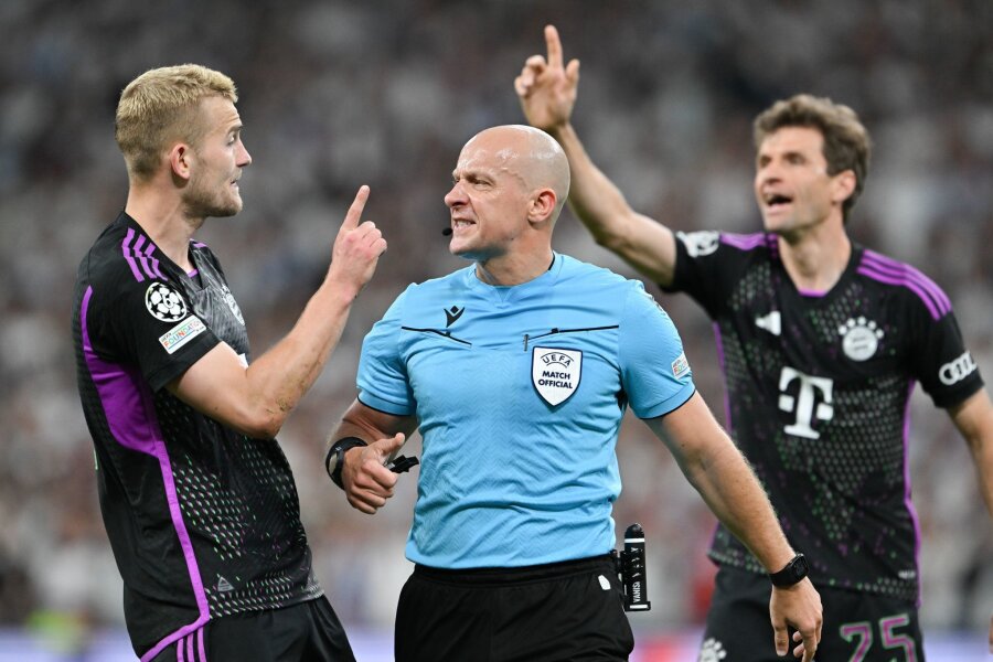 Kroos kritisiert verfrühten Abseitspfiff gegen FC Bayern - Die Münchner Matthijs de Ligt (l) und Thomas Müller beschweren sich bei Schiedsrichter Szymon Marciniak über die Abseitspfiff.