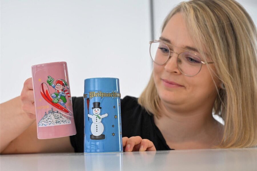 Kürzer, aber vielfältiger: Was der Chemnitzer Weihnachtsmarkt 2023 zu bieten hat - Veranstaltungsleiterin Kathleen Herold zeigt die diesjährigen Glühweintassen für den Chemnitzer Weihnachtsmarkt. Die Tassen werden vom Eichamt überprüft.