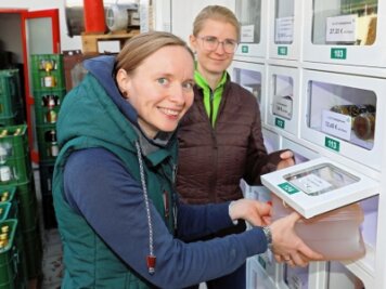 Kult-Glühwein gibt es jetzt rund um die Uhr - Doreen Bönsch (vorn) testet den Automaten. Auch Ulrike Mehlhorn ist überzeugt, dass das Angebot bei den Kunden gut ankommt.