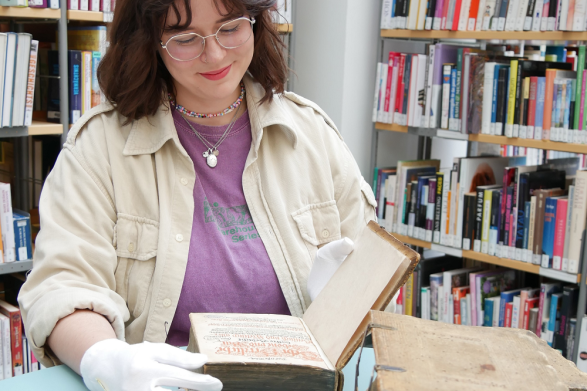 Kulturerbe auf dem Patientenstuhl: Stadtbibliothek Chemnitz rettet historische Bücher - Luisa Kahnt, Auszubildende der Stadtbibliothek, blättert in den geretteten Büchern.
