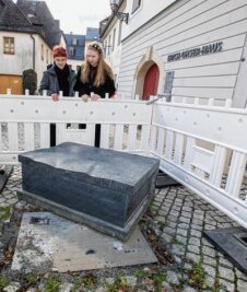 Kunstbank vor Ohser-Haus in Plauen mehrfach demoliert - Die Buchbank aus Theumaer Naturstein wurde gewaltsam von ihrem Sockel geschoben. Die Galerie-Mitarbeiterinnen Luca Wunderlich (links) und Sarah Kühnel begutachten den Schaden. 