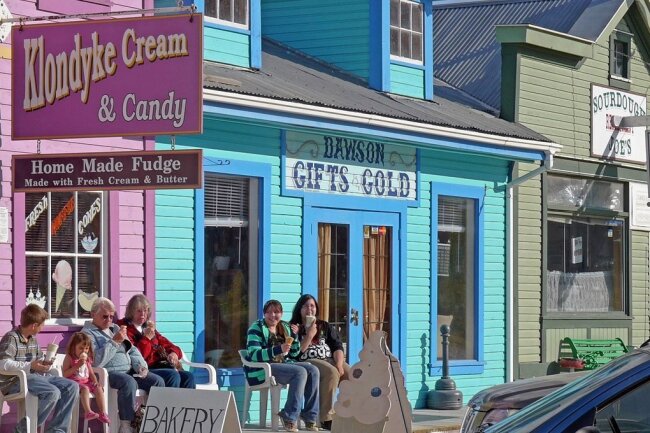 Blick auf historische Gebäude in Dawson City in Kanada - Mitbringsel aus Gold gibt es hier auch noch, wie das Schild am türkisfarbenen Laden zeigt. 