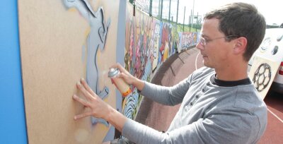 Längste Galerie im Vogtland: Plauener Graffiti-Sprayer peppen Mauer auf - André Bretschneider bei der Arbeit: Er leitet das Graffiti-Projekt auf dem Kurt-Helbig-Sportplatz.