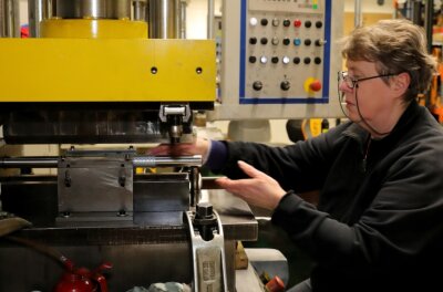 Lafortec in Grünhain fertigt Kurzrohre aller Art - Mitarbeiterin Sylvia Dichte an einer Presse, mit deren Hilfe die gestanzten und zugeschnittenen Metalle zu Rohren geformt werden. 