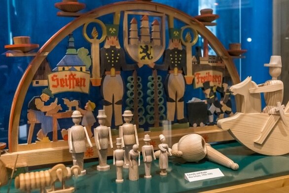 In einer Vitrine im Seiffener Spielzeugmuseum sind mehrere Figuren aus Naturholz zu sehen, die von Max Schanz entworfen wurden. 