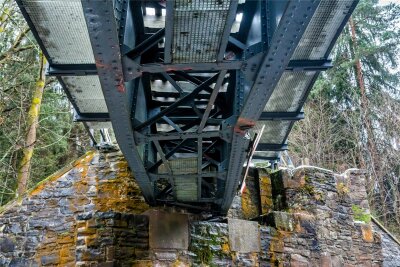 Lastwagenfahrer zerstört Brücke im Erzgebirge: Eisenbahnstrecke und Staatsstraße komplett gesperrt - Blick von unten: Der Schaden an der Eisenbahnbrücke bei Pockau-Lengefeld ist deutlich zu sehen.