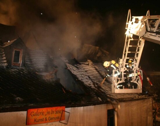 Lebenswerk geht in Flammen auf - 
              <p class="artikelinhalt">Vom Korb der Drehleiter aus versuchen Feuerwehrleute, der Flammen Herr zu werden. </p>
            