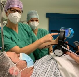 Leisnig: Kino im OP-Saal - Mandy Büttner und Almut Trapperklären einem Patienten, wie die Happymed-Brille anzuwenden ist. 