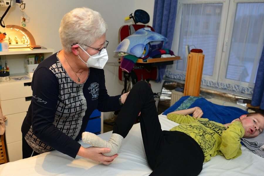 Physiotherapeutin Ulrike Hesse vom Diakonischen Werk Rochlitz betreut Lucas Franz schon seit 1999. Ein Mal in der Woche macht sie mit ihm in der Wohnung in Mittweida Übungen, die seinen Bewegungsapparat stabilisieren.