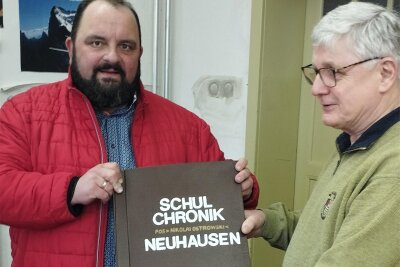Leser hungrig auf Schulchronik - Joachim Horschig hat die Chronik von Neuhausen entdeckt und Bürgermeister Andreas Drescher überreicht.
