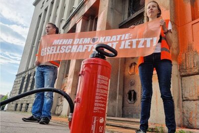 Letzte Generation: Kritik an der Farbattacke auf das Deutsche-Bank-Gebäude - Mit Feuerlöschern sprühten die Aktivisten Farbe ans Gebäude. Gegen sie wird wegen Sachbeschädigung ermittelt.