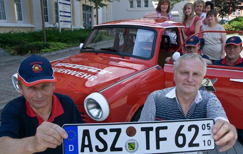 Letztes Kennzeichen geht an einen Roten - Ein besonderes Kennzeichen für ein besonderes Auto: Gerd Winterstein (rechts) von der Zulassungsstelle in Aue überreicht Horst Löscher von der Trabantfeuerwehr Grüna das letzte ASZ-Nummernschild. 