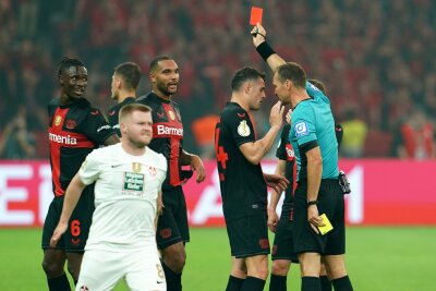Leverkusen gewinnt Pokal und macht das Double perfekt - Bayer-Verteidiger Odilon Kossounou (l) sah noch vor der Pause die Gelb-Rote Karte.