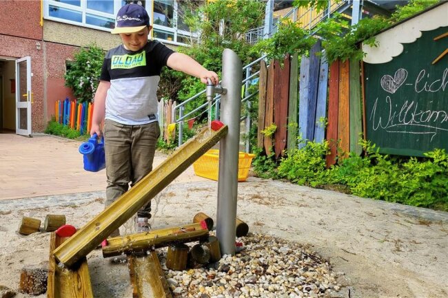 Lößnitzer Knirpsenland weiht neuen Garten ein - In der neuen Matschecke können die Kinder Wasserstrecken aufbauen. Nicht nur Felix hat jede Menge Spaß dabei. 