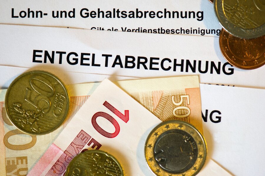 Auf Abrechnungsformularen liegen Euromünzen und -Geldscheine.