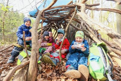 Mädchen und Jungen der Plauener Kita Pusteblume erleben drei Wochen lang den Wald hautnah -  Elise, Lea, Kolja und Julius frühstückten am Donnerstagvormittag gemeinsam in eine der selbstgebauten Hütten aus Holz.