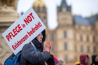 Mangel an Ärzten und Pflegekräften droht zu wachsen - Bei einer Protestaktion vor dem Schweriner Landtag hält eine Teilnehmerin ein Schild mit der Aufschrift "Pflege in Not - Existenzen bedroht!".