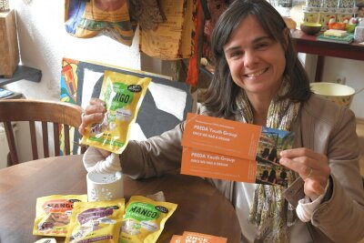 Mango aus der Tüte und Theatertickets für ein besonderes Gastspiel in Freiberg - Naima Bouzoubaa von der Fairtrade Town-Gruppe Freiberg wirbt mit Karten und Produkten für das Stück zu Kinderrechten.