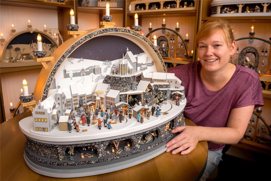 Manufaktur aus Seiffen zeigt Freiberg in einem mechanischen Schwibbogen - Kunsthandwerkerin Jenny Mattheß mit dem mechanischen Großschwibbogen, der die Stadt Freiberg zeigt.