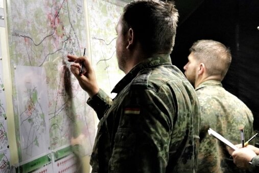 Offiziere besprechen das taktische Vorgehen an der Lagekarte.