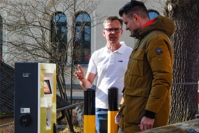 Markneukirchen erhält seine ersten E-Lade-Säulen - Udo Rosenzweig (links) von GK Software erläutert Markneukirchens Bürgermeister Toni Meinel (parteilos) die E-Ladesäule am Oberen Markt.