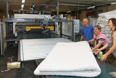 Matratzenhersteller in Langenhessen investiert in Verpackungsmaschine - Lisa Kaczmarek, Anet Altmannshofer und Achmed Barth (von rechts) bestückten die neue Verpackungsmaschine mit einer Matratze.