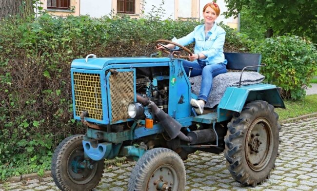 Moderatorin Beate Werner steuert den Traktor sicher vom Sportplatz über die Lindenallee in den Hof von Schloss Blankenhain. 