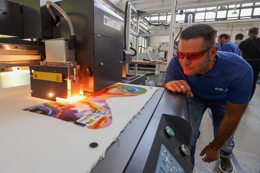 Demonstration digitaler Prozesse im Sächsischen Textilforschungsinstitut: Techniker Yves Schwarzmann überwacht einen Drucker, der den Stoff für eine Spielmatte bedruckt. 