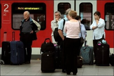 Mehr Geld bei Verspätung, Taxi und Hotelunterkunft - Reisende stehen im Kölner Hauptbahnhof neben einem Regionalexpress, der "Nicht einsteigen" anzeigt Bahnreisende bekommen jetzt mehr Rechte bei Verspätungen oder Ausfällen. (Archivfoto)