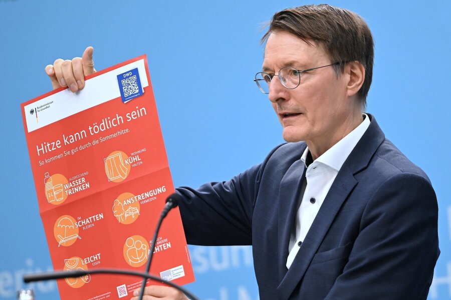 Mehr Vorbeugung gegen Hitzetote im Sommer - Bundesgesundheitsminister Karl Lauterbach (SPD) hält ein Plakat zum Thema Hitzeschutz hoch.