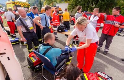 Mehrere Schwerverletzte bei Feuerwehreinsatz in Rothenthal - Einsatzkräfte des Rettungs- und Katastrophendienstes checken die am Brandbekämpfungseinsatz beteiligten Feuerwehrleute und Polizeibeamten auf dem Hof durch.