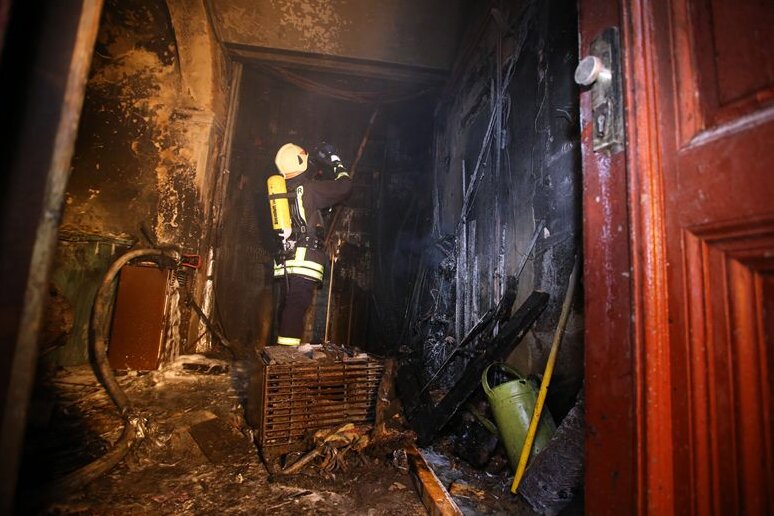 Mit einer Wärmebildkamera sucht ein Feuerwehrmann noch nach Brandherden in der Wand.