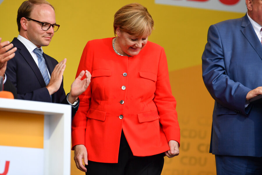 Merkel bei Wahlkampfauftritt in Heidelberg mit Tomaten beworfen - Bundeskanzlerin Angela Merkel schaut in Heidelberg auf dem Universitätsplatz bei einer Wahlkampfveranstaltung auf einen Fleck auf ihrer Jacke. Ein Tisch, der vor ihr stand, war von einem Gegenstand aus den Reihen des Publikums getroffen worden, dabei waren Spritzer auf Merkels Jackett gekommen.