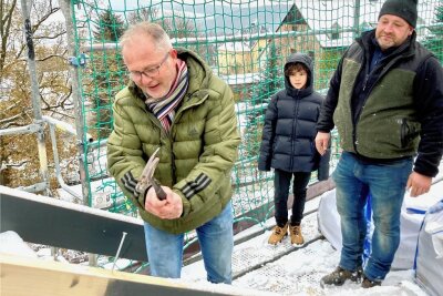 Millionenprojekt: Richtfest für Wohnpark in Bernsbach - Manfred Jahn schlug unter den Augen seines Sohns Max und Zimmerer André Wiedrich aus Beierfeld beim Richtfest den letzten Nagel ins Holz. 