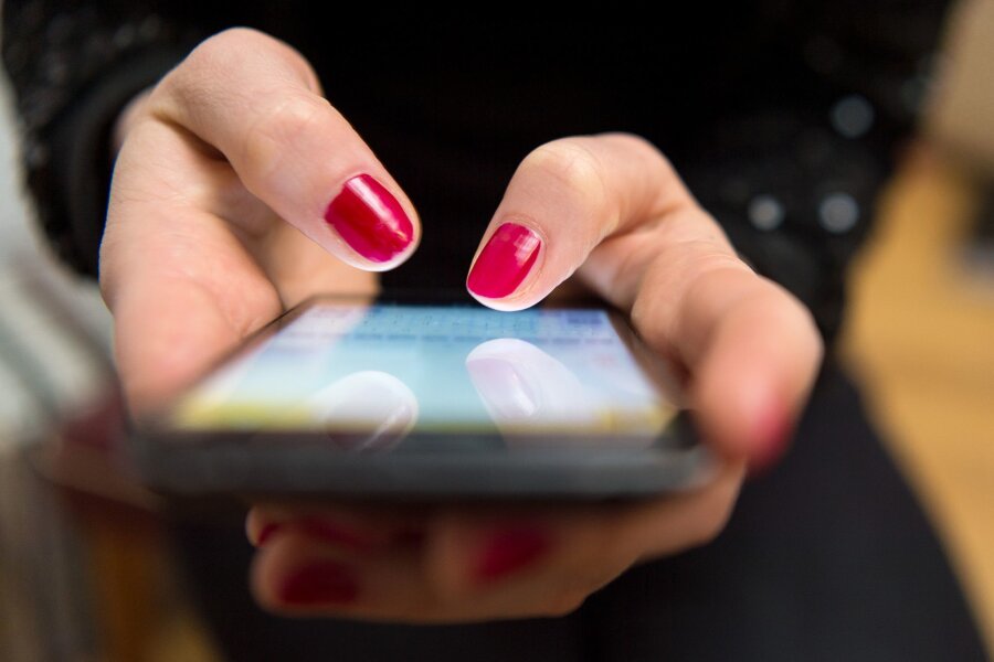 Millionenschaden durch Liebes-Betrugsmasche - Eine Frau tippt auf einem Smartphone.