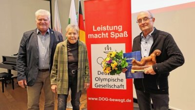 "Mister Triathlon" geehrt - Der Vorsitzende Wolfgang Beuschel (links) und Gabriele Lehmann von der DOG-Stadtgruppe Zwickau überreichten Wolfgang Hertrampf (rechts) den Preis für vorbildliche Sportförderung. 