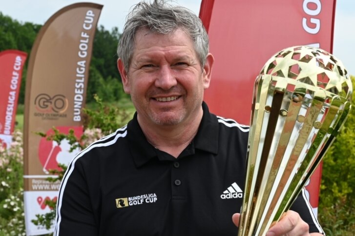 Veranstalter Jens Karluß hält die Trophäe in den Händen, um die es geht: den Bundesliga-Golf-Cup. 