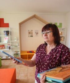Mit Baby in die Bibliothek - Kultur-Sachgebietsleiterin Ramona Hofmann räumt Bücher ein.