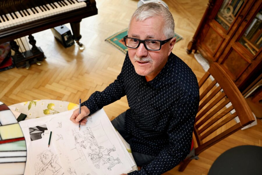Mit Bleistift und Pinsel das Alltagsgeschehen im Blick: Grünhainichener zeichnet Karikaturen - Frank Schubert am Wohnzimmertisch. Hier entstehen seine Bilder.