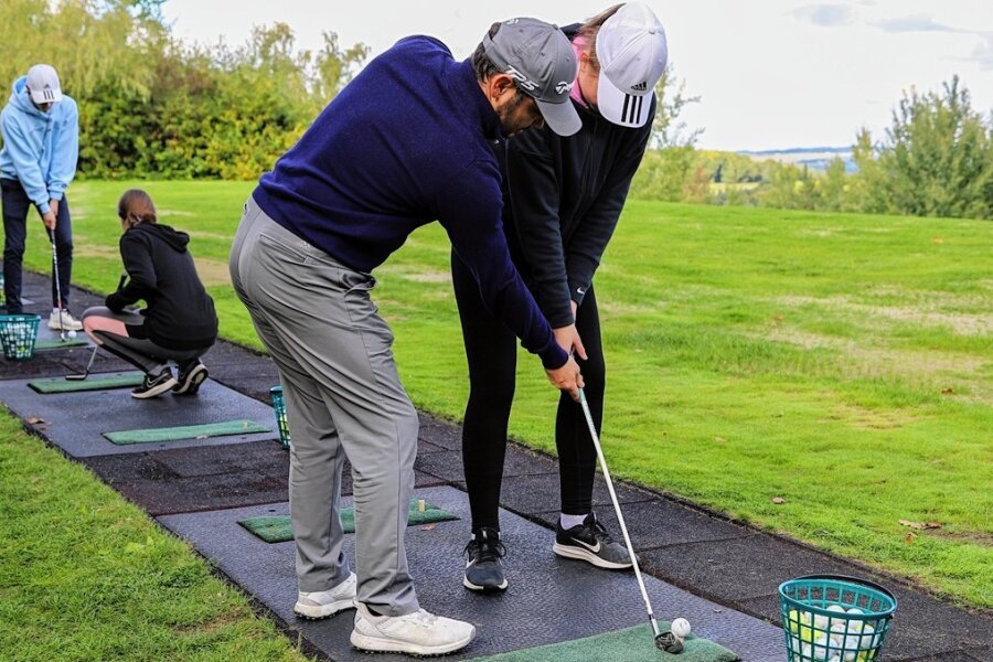 Golflehrer Denny Matthias gibt Lea Günther Tipps zum Abschlag.